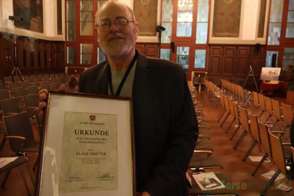 Klaus Treuter hält im Merseburger Ständehaus die Urkunde zur Bürgermedaille der Stadt Merseburg während des Neujahrsempfangs 2026.