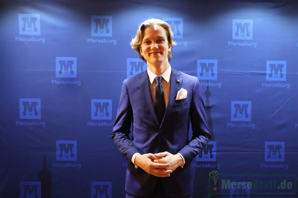 Moritz Eichelmann, FDP-Stadtrat, steht beim Neujahrsempfang der Stadt Merseburg 2026 vor dem Veranstaltungsbanner.