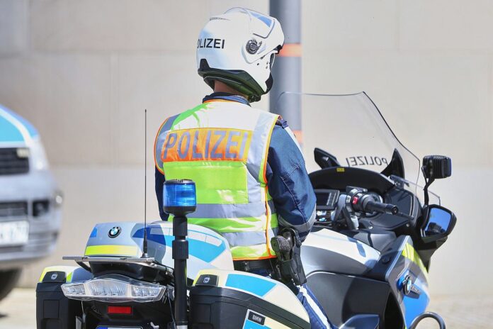 Polizeikontrolle am Steuer (Symbolbild) Ein Polizeibeamter sitzt auf einem Dienstmotorrad, im Hintergrund ein weiteres Polizeimotorrad.